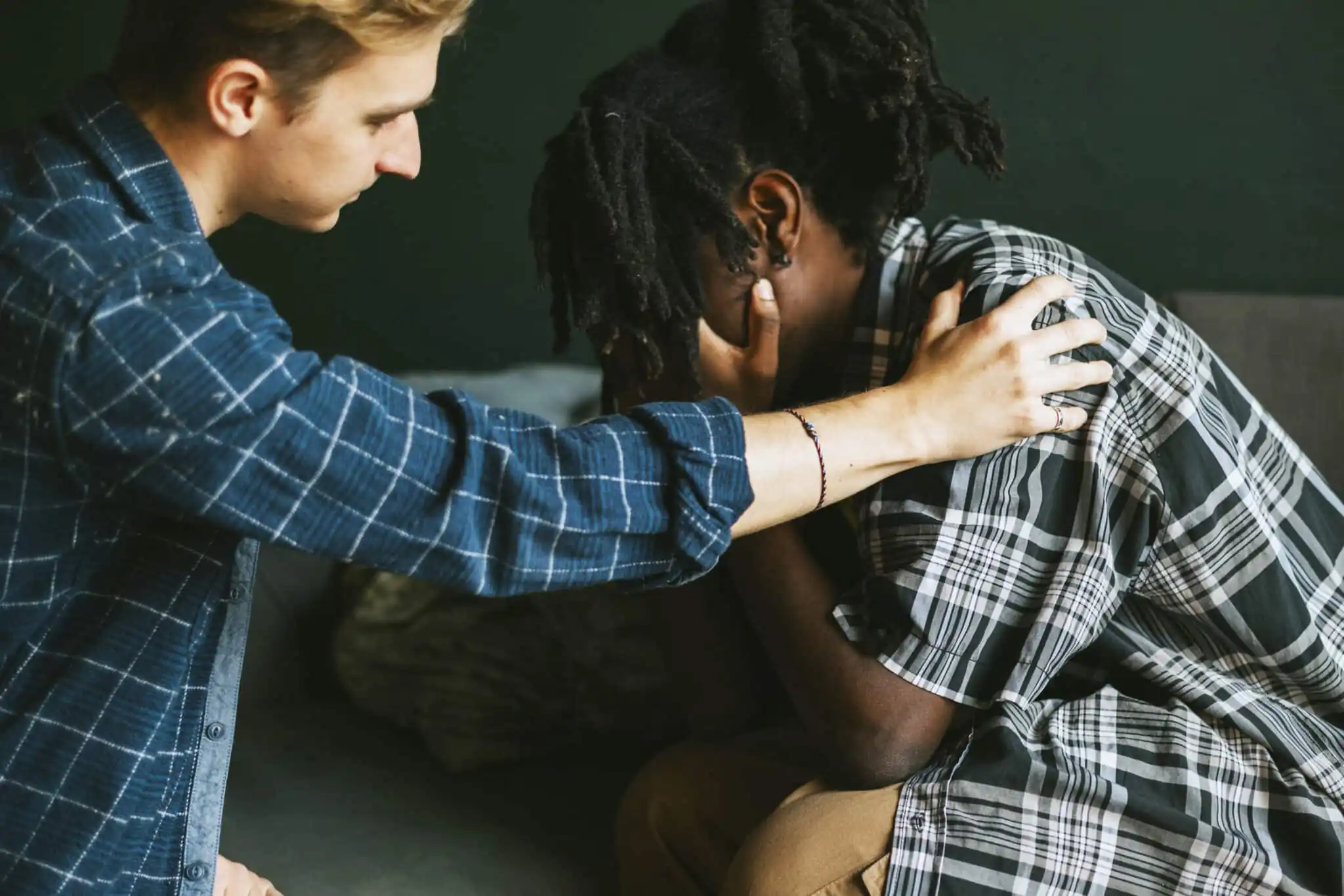 A man comforting a woman with his hand on her shoulder for the topic how to convince someone to go to rehab.