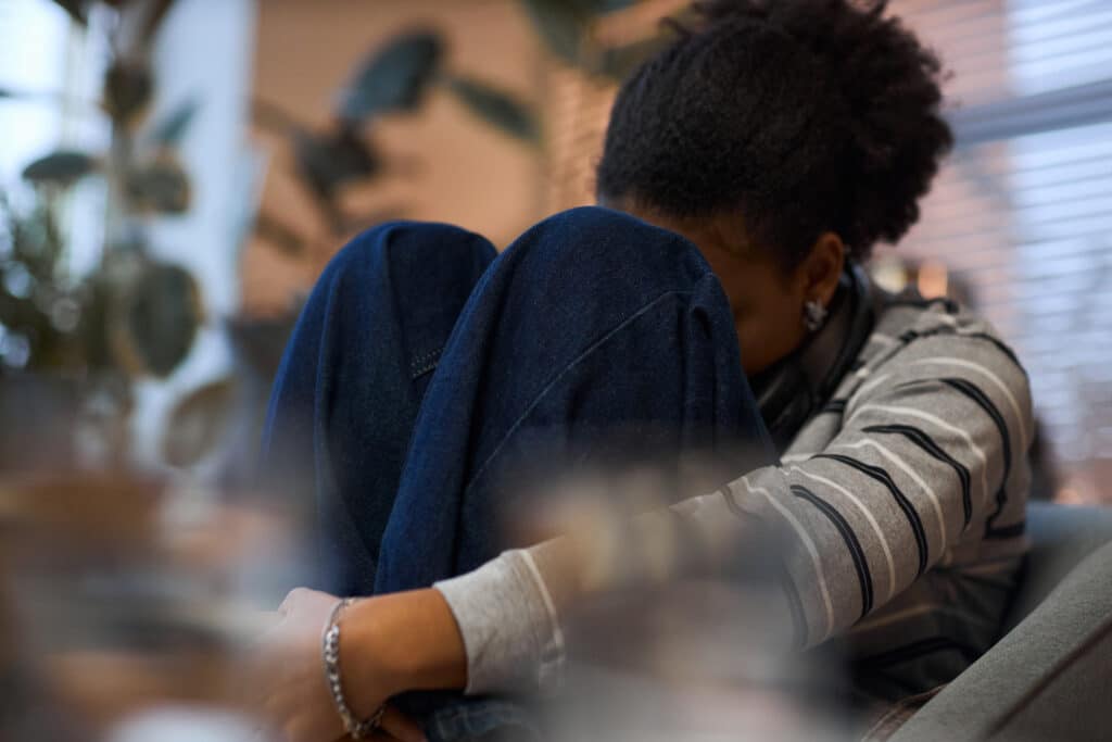 Person sitting with knees drawn to chest during a difficult moment